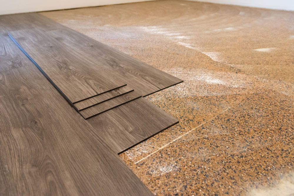 A Wooden Floor is Being Installed in a Room — Bayside Carpets & Flooring in Lake Cathie, NSW