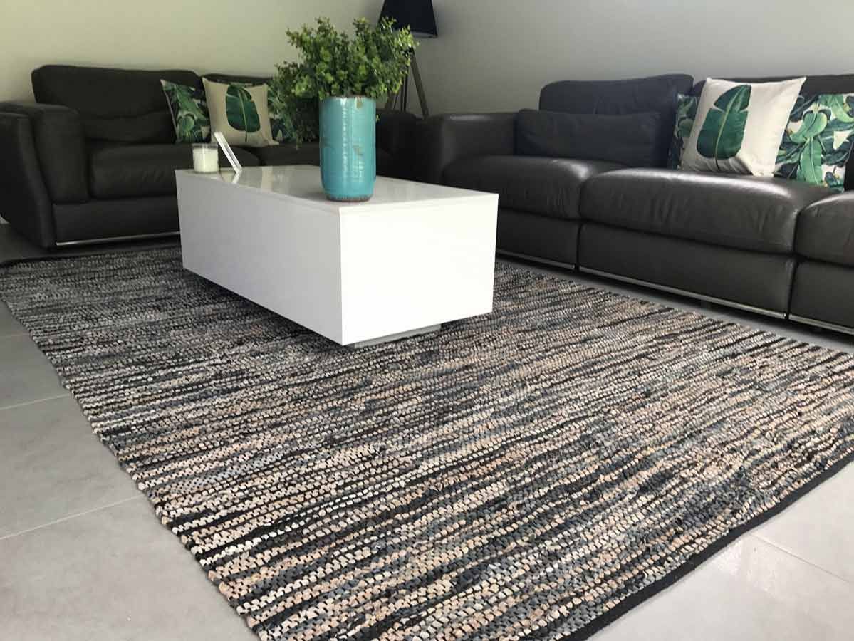 A Living Room With Two Couches, a Coffee Table and a Rug — Bayside Carpets & Flooring in Lake Cathie, NSW