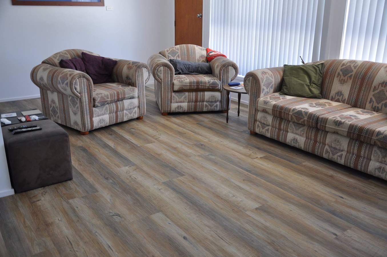 A Living Room Filled With Furniture and a Wooden Floor — Bayside Carpets & Flooring in Lake Cathie, NSW