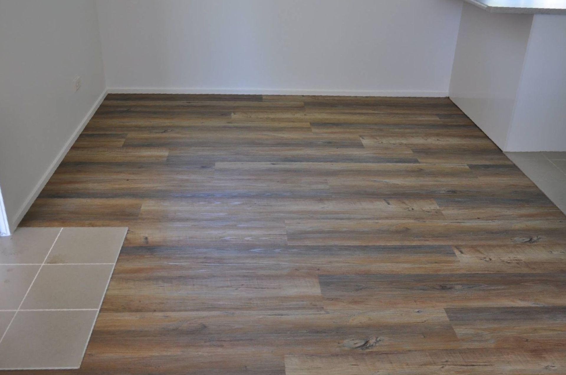 A Room With a Wooden Floor and White Walls — Bayside Carpets & Flooring in Port Macquarie, NSW