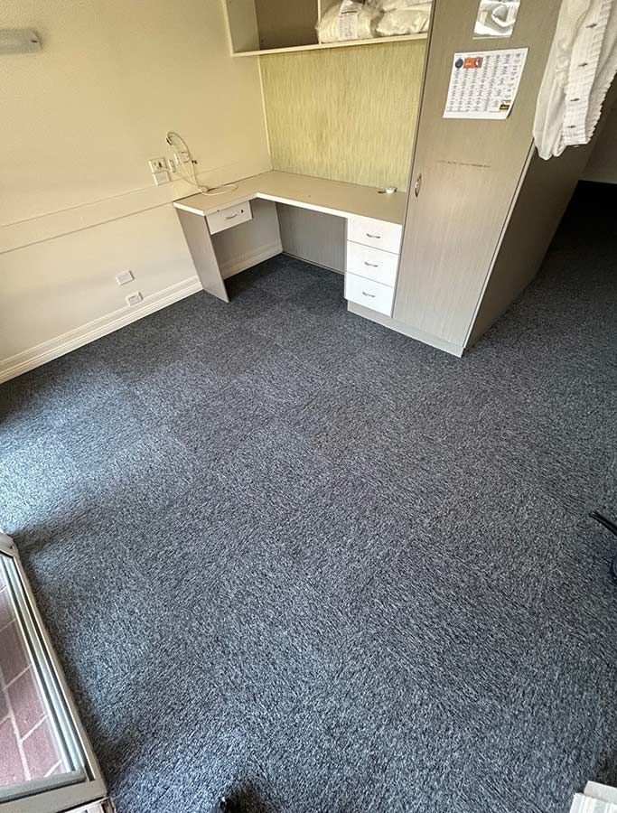 A Room With a Desk and a Carpeted Floor — Bayside Carpets & Flooring in Laurieton, NSW