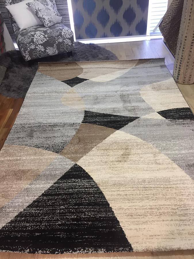 A Rug With a Geometric Pattern is Sitting on the Floor in a Living Room — Bayside Carpets & Flooring in Laurieton, NSW
