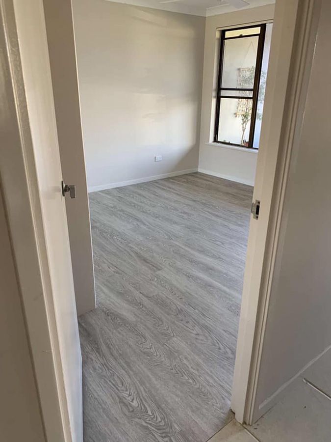 A Room With a Wooden Floor and a Window — Bayside Carpets & Flooring in Laurieton, NSW