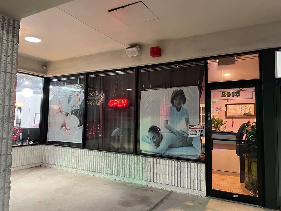 A woman is getting a massage in the window of a massage parlor.