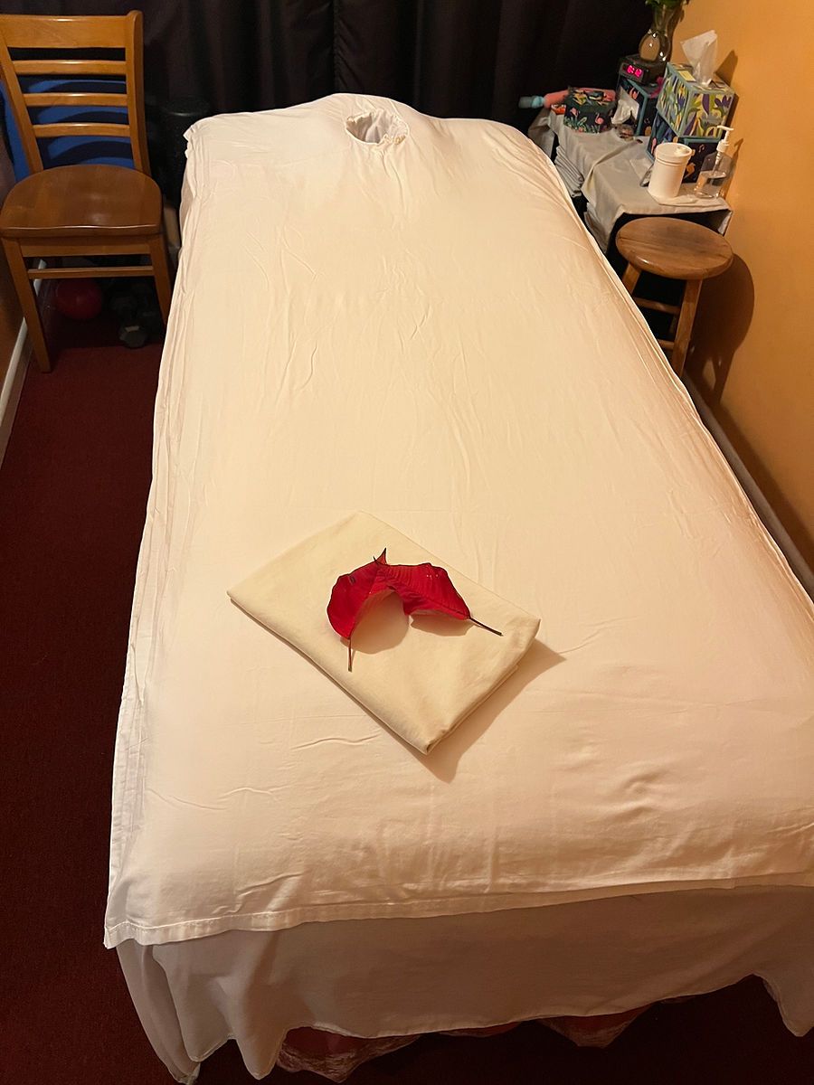A massage table with a flower on it in a room.