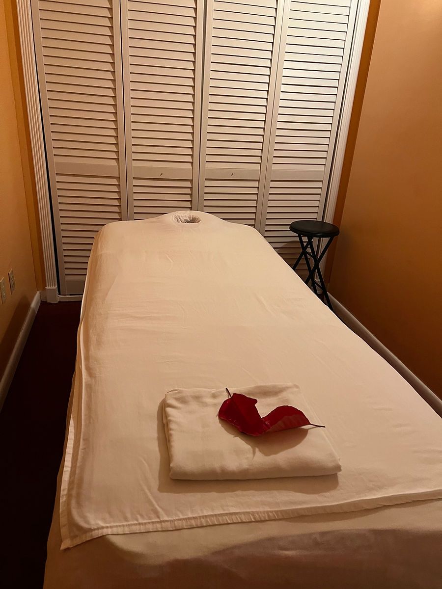 A massage table in a room with shutters on the wall.