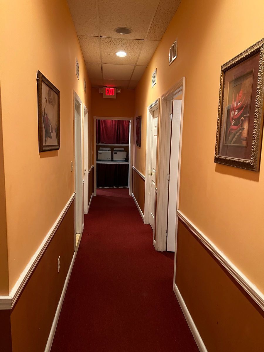 A long hallway with a red exit sign on the ceiling