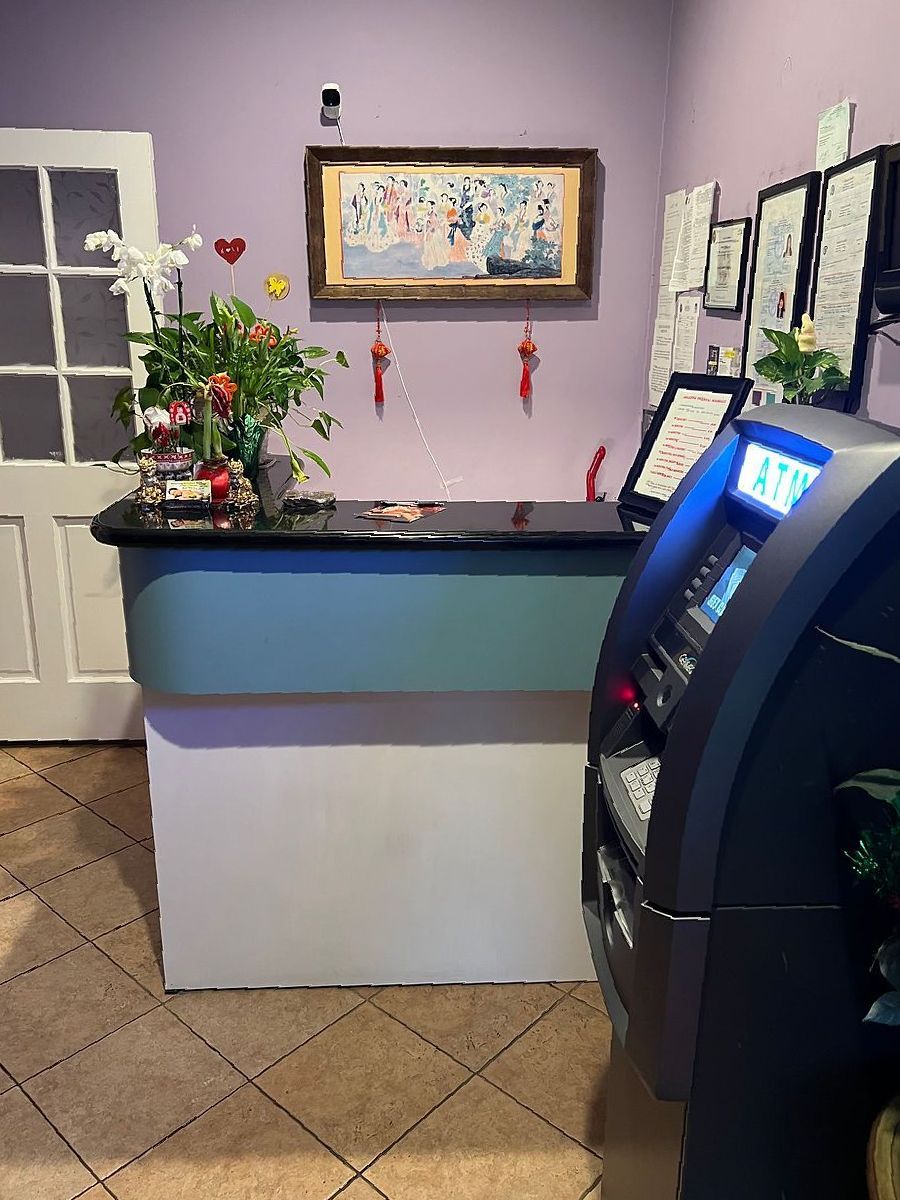 A room with a counter and an atm in it.