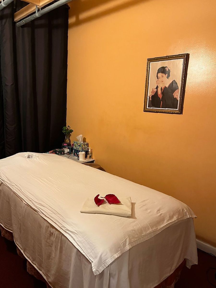 A massage table in a room with a picture on the wall above it.