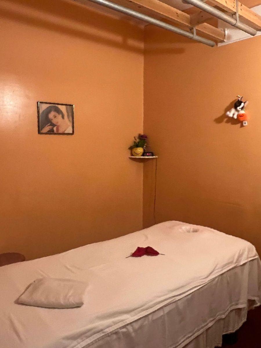 There is a picture of a woman on the wall above the bed.