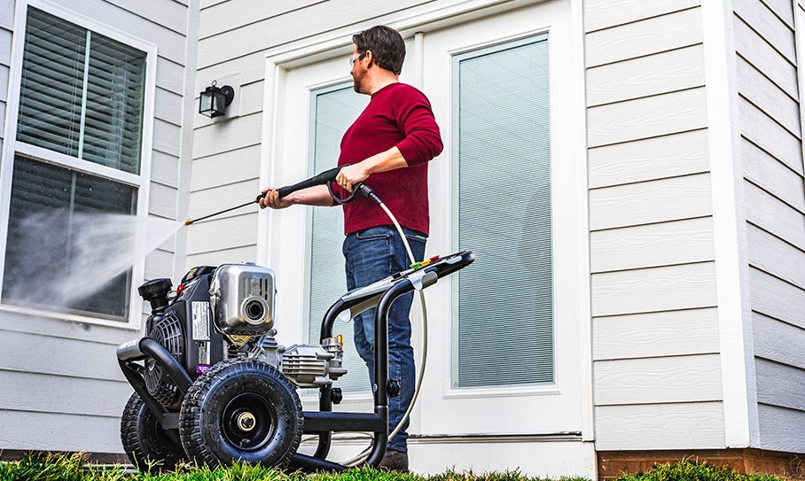 a man is using a pressure washer outside of a house