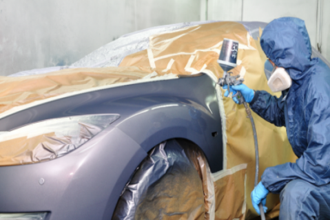 Employee applying fresh coat of paint to a car - auto body repair in Layton, UT