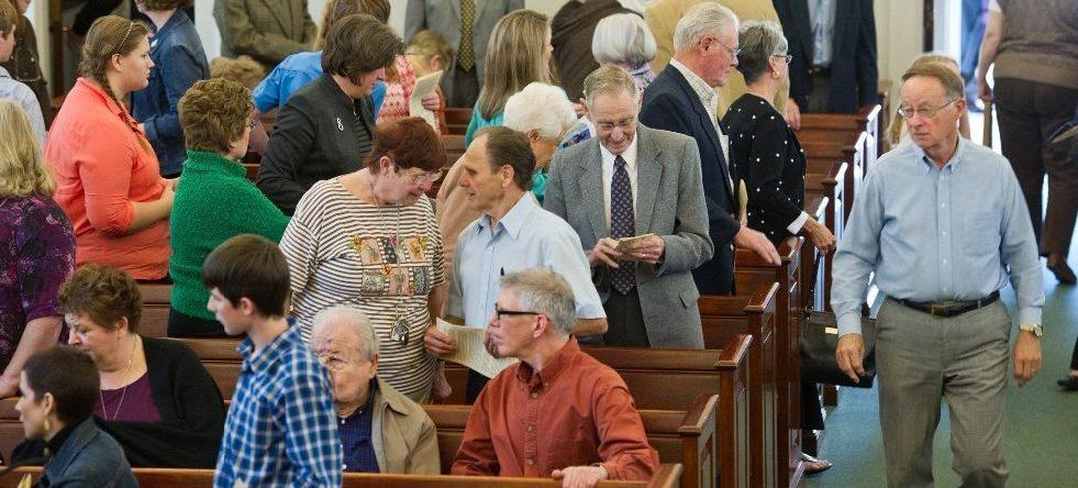 A large group of people are sitting in a church.