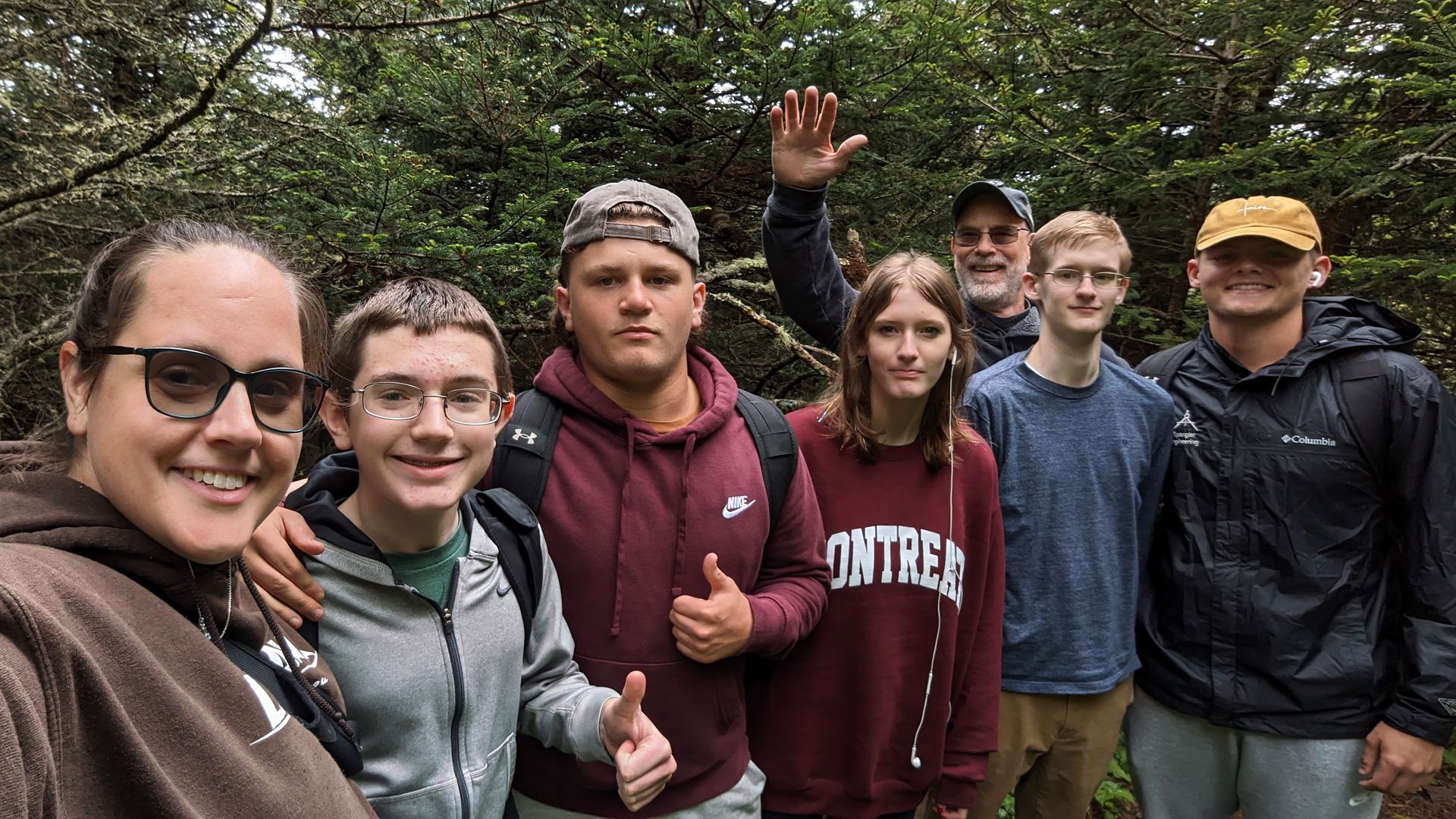 A group of people are standing in a circle with their arms around each other.