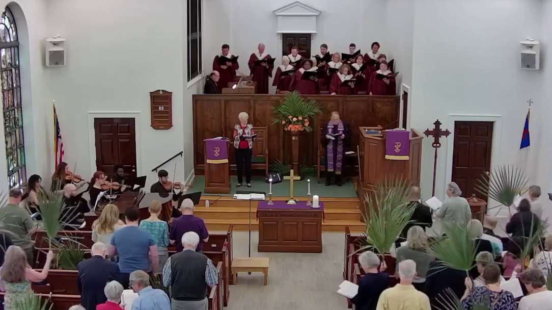 A large group of people are standing in a church.