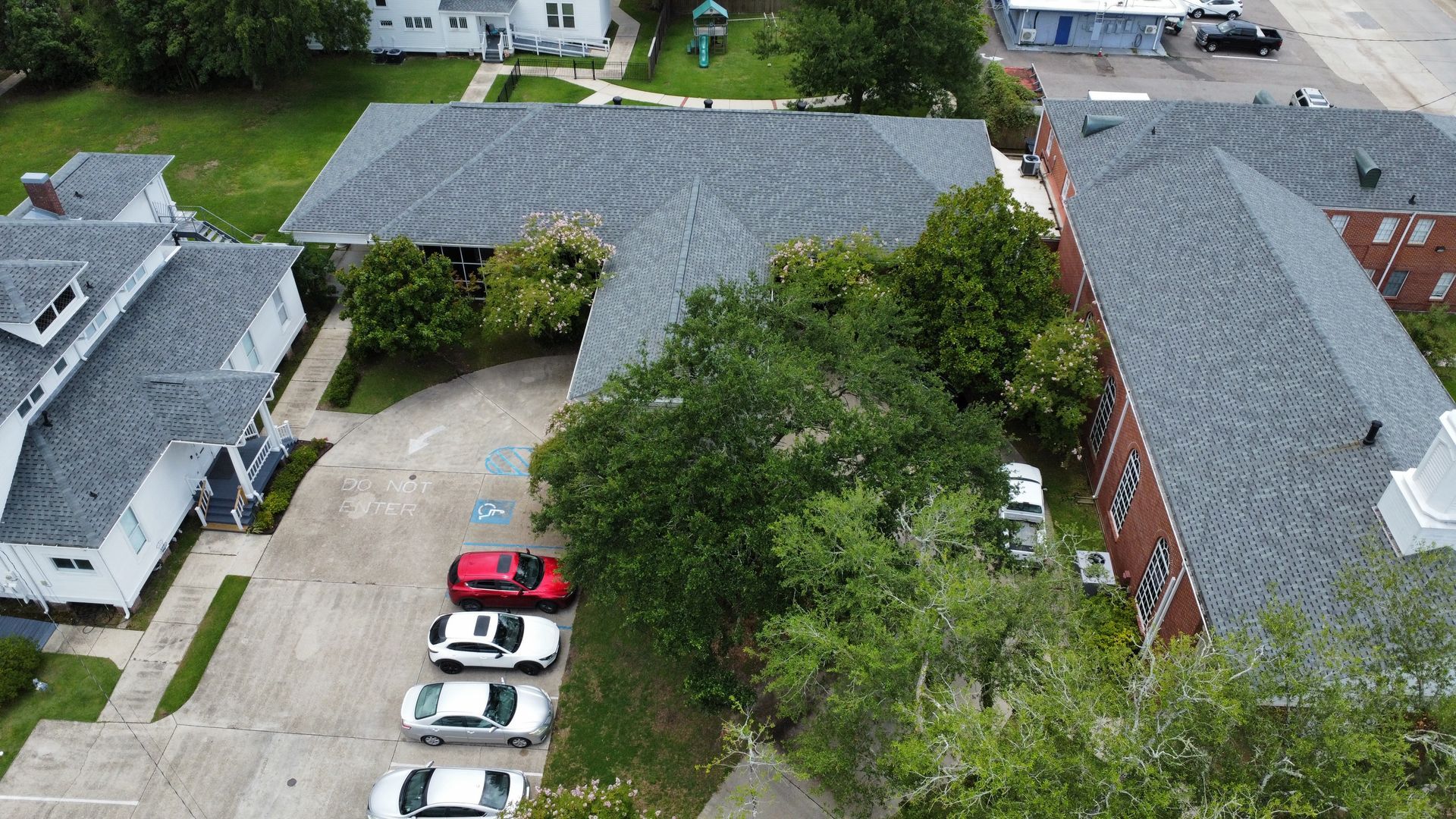 An aerial view of a row of cars parked in front of a building.