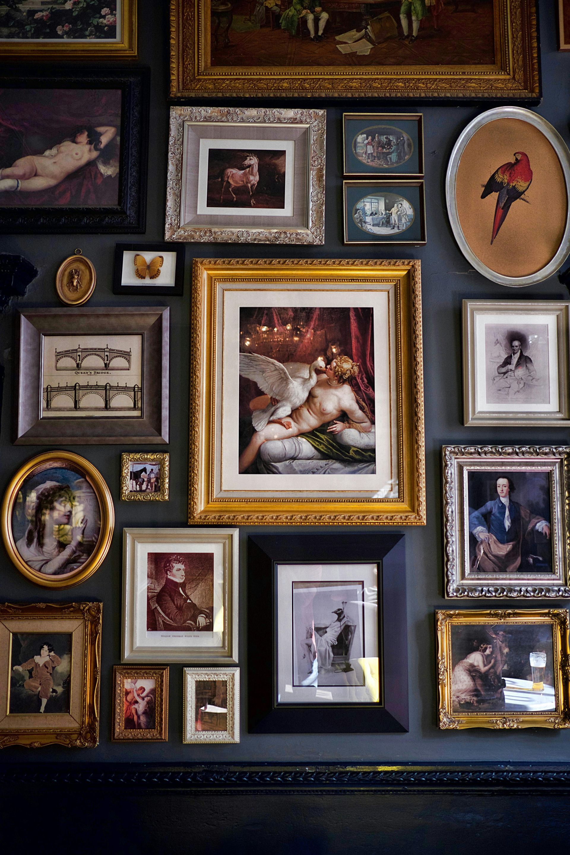 A wall with a lot of framed pictures on it