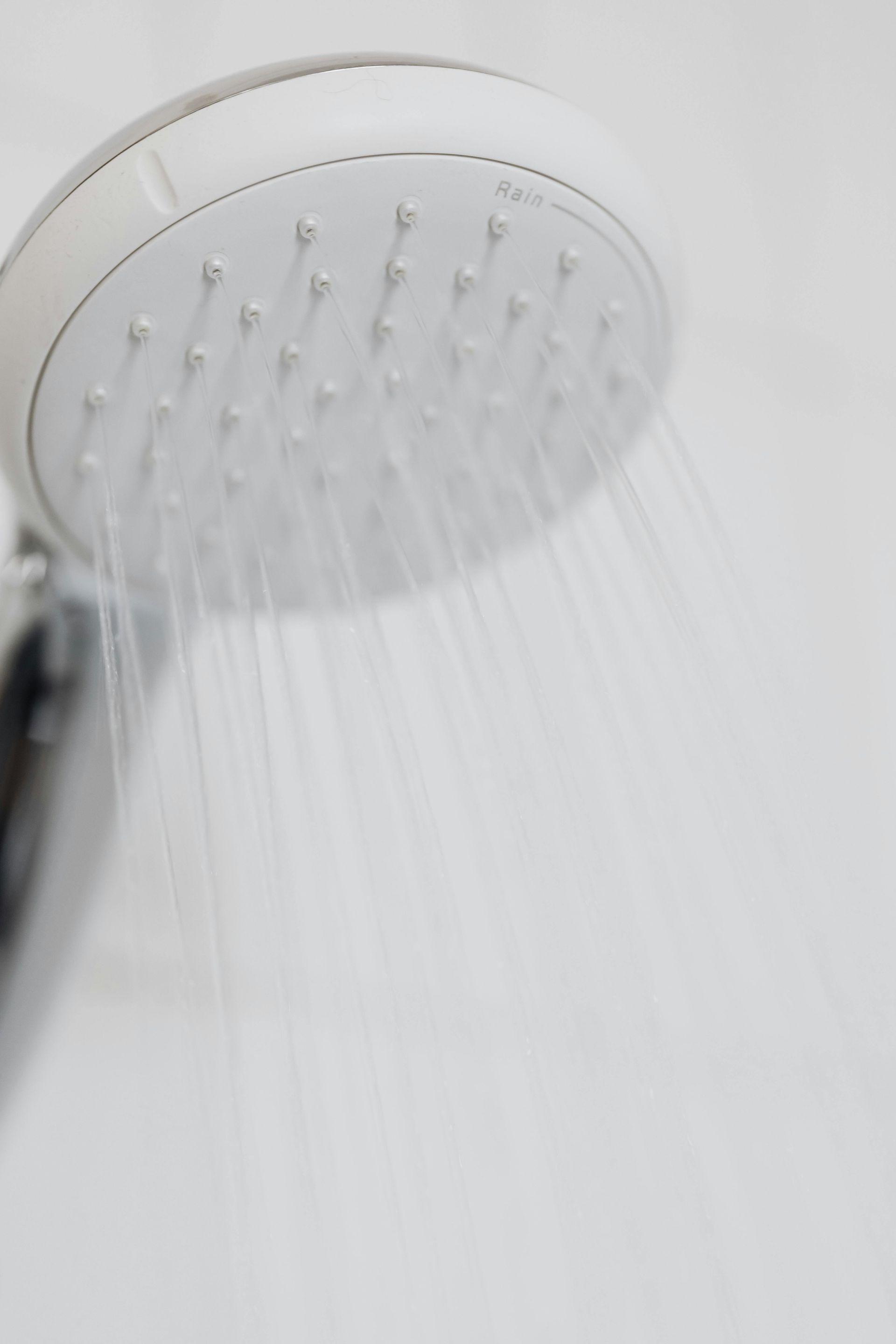 A close up of a shower head with water coming out of it.