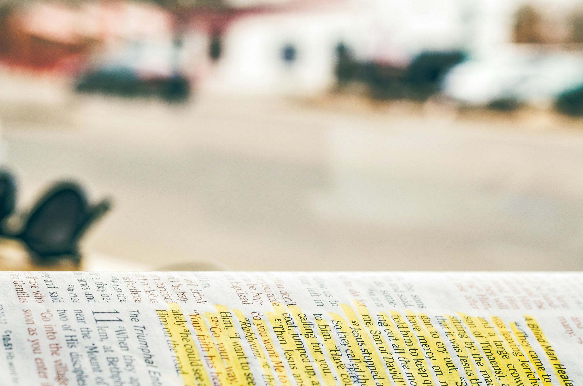 A newspaper is sitting on a table with a blurry background.
