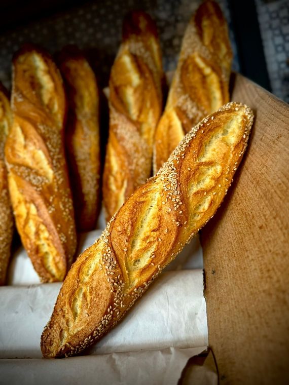 Vassoio di girelle di pasta sfoglia cotte al forno con ripieno scuro a spirale e erbe aromatiche o verdure.