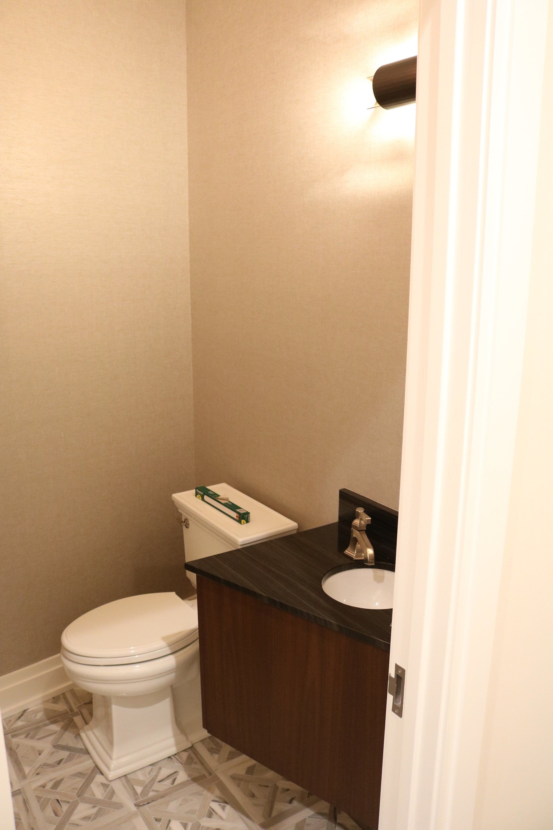 Small bathroom with a toilet, vanity, and neutral-colored walls.