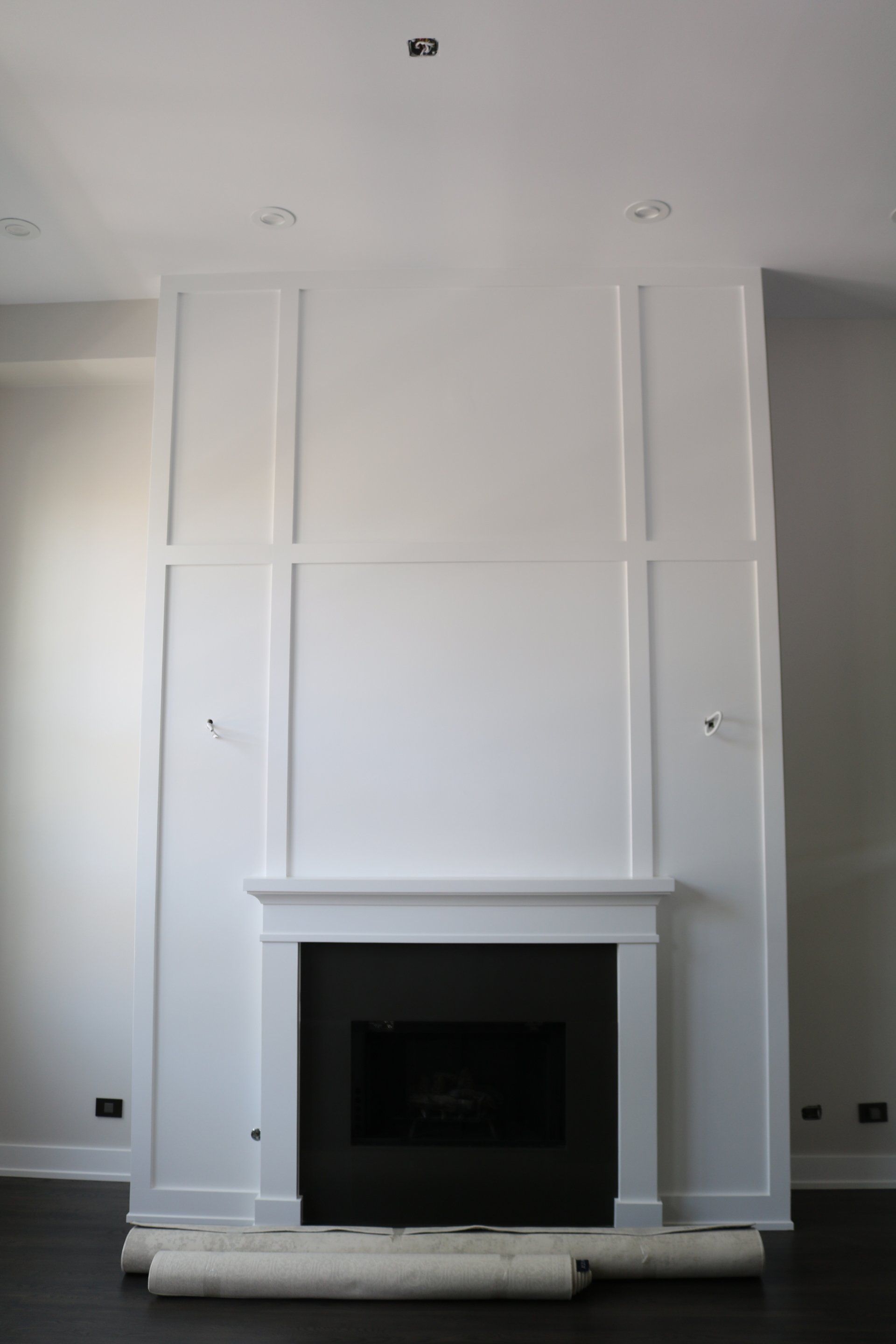 White fireplace with black insert, built into a wall with white trim.
