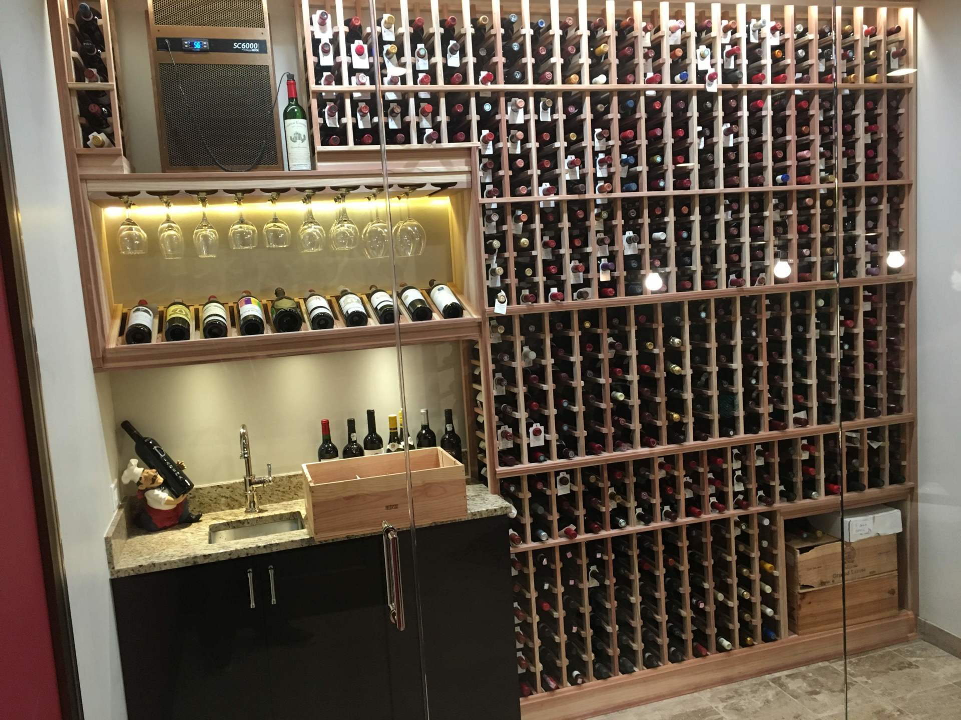 Wine cellar with wooden racks, bottles, and a small bar area.