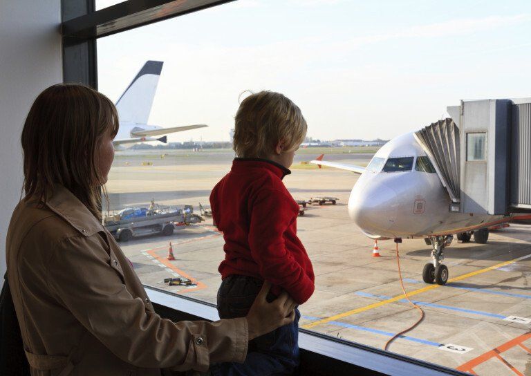 young child and a woman look at a plane
