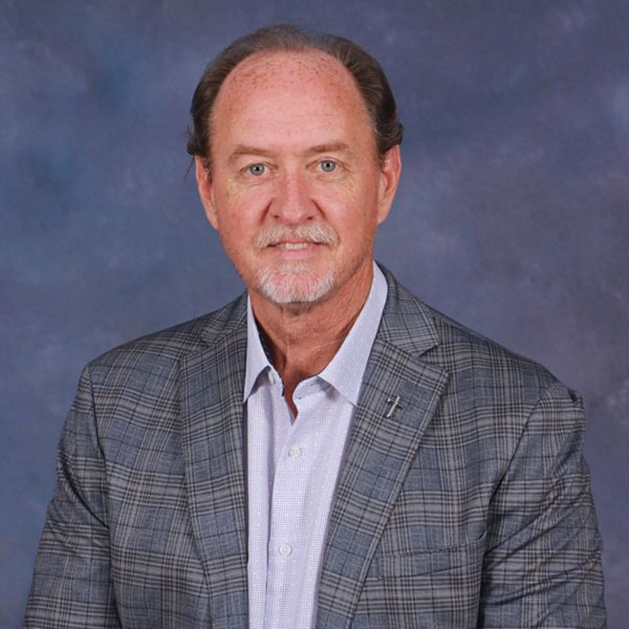 A man wearing a jacket and blue shirt