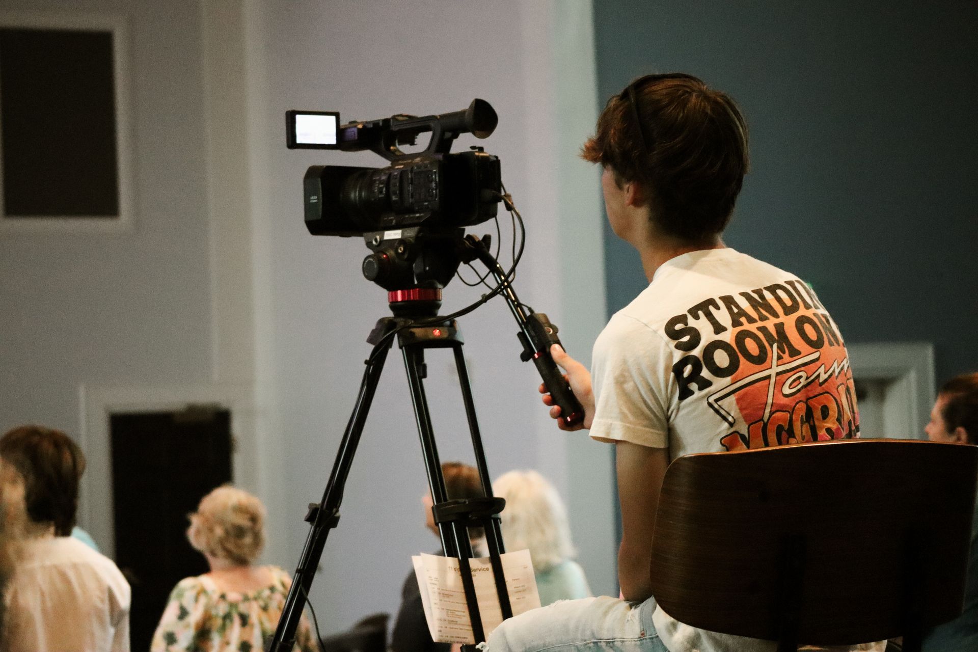 A man is sitting in front of a video camera.