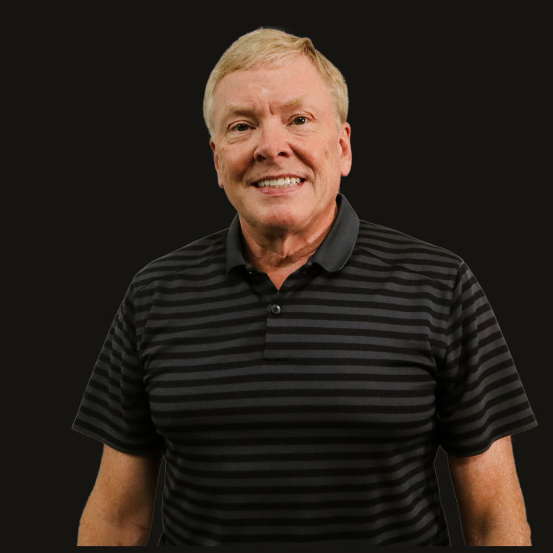 A man wearing a black and grey striped shirt is smiling for the camera.