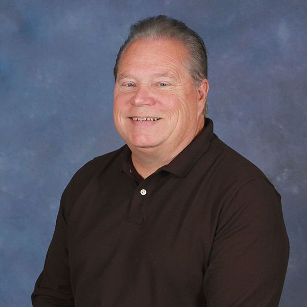 A man in a plaid shirt is smiling for the camera.