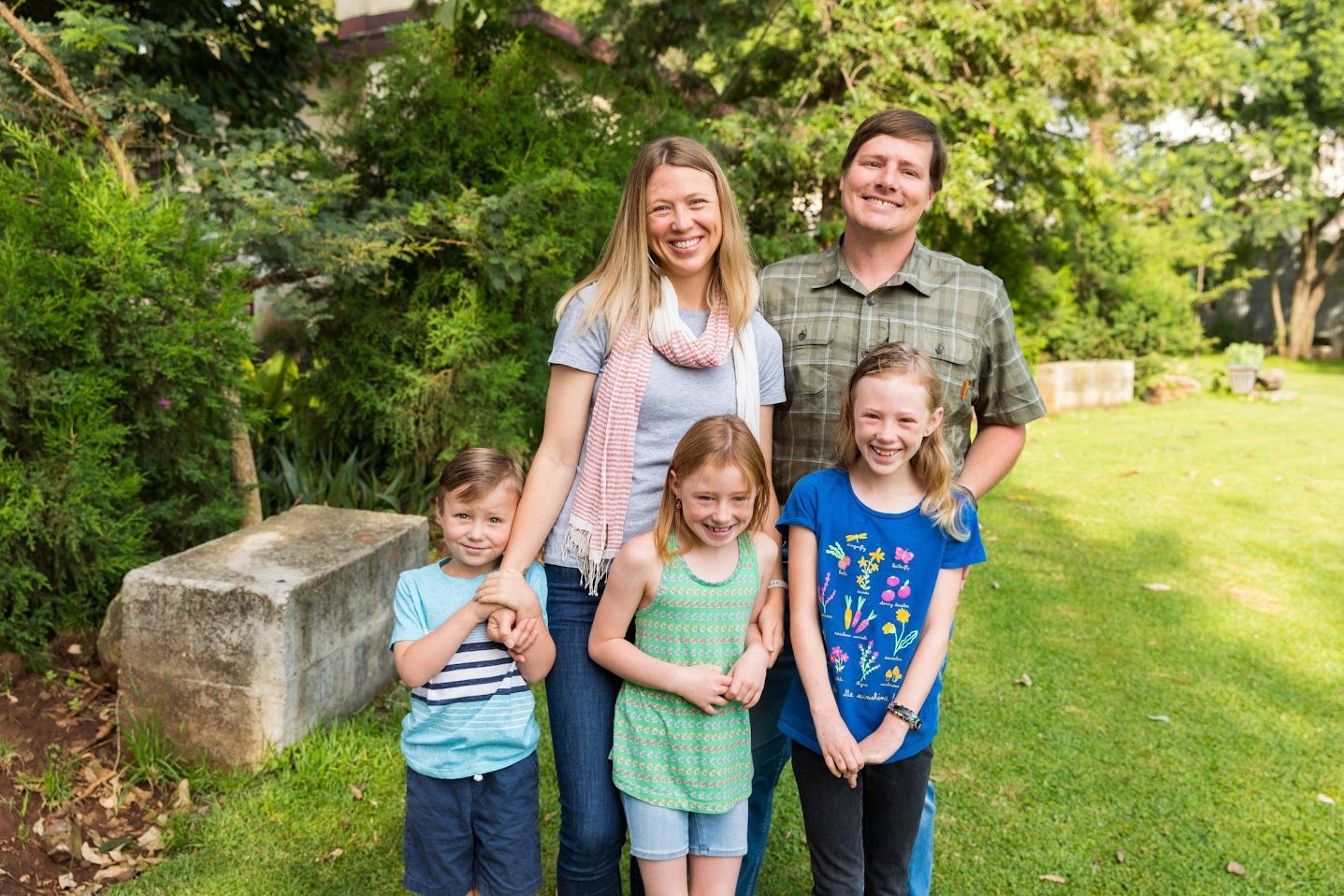 A family is posing for a picture in a park.
