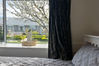 a bedroom with a window looking out to a garden