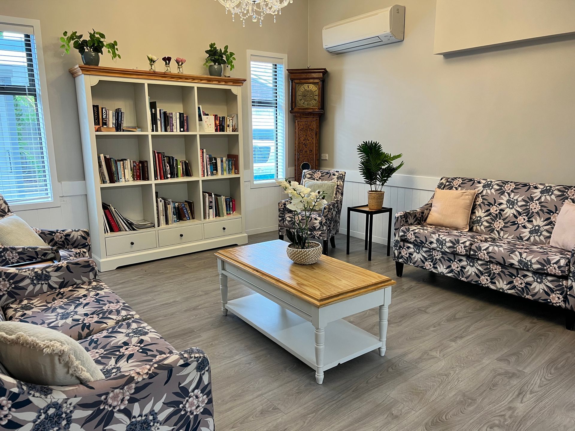 A living room with two couches , a coffee table , and a bookshelf.