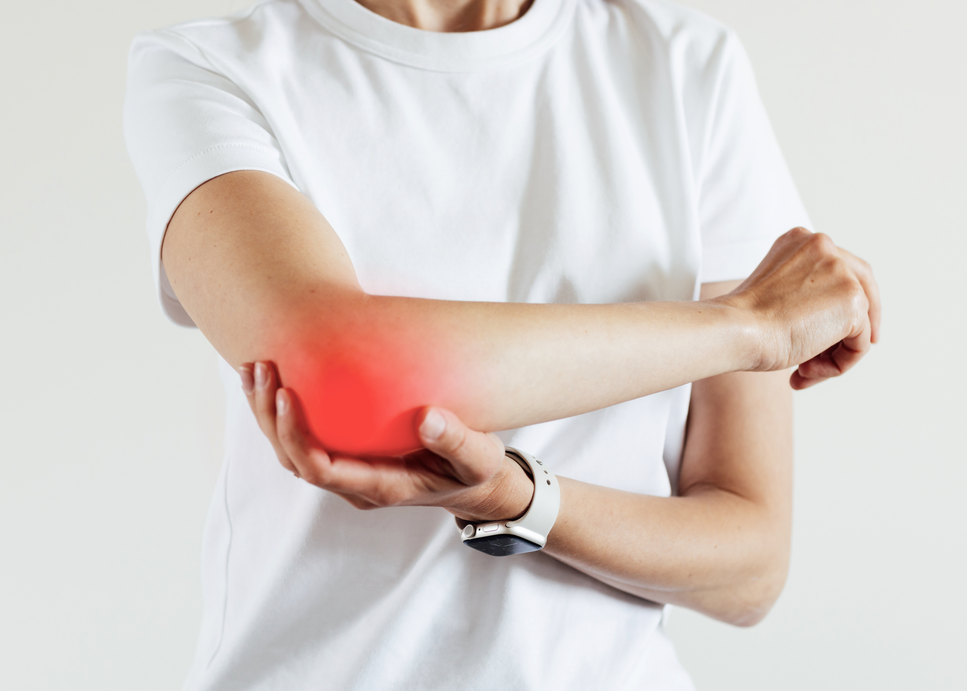 Uma mulher está segurando o cotovelo com dor.