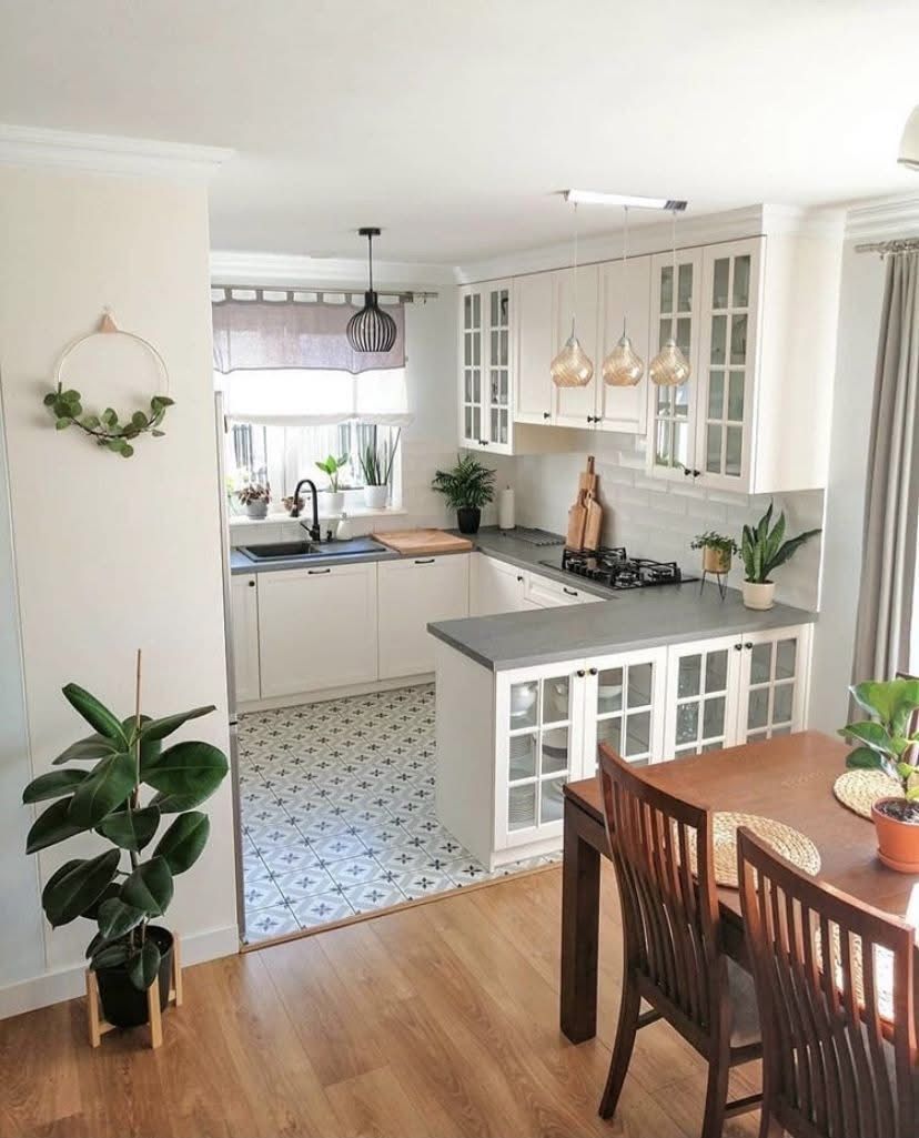 Cozy kitchen with white cabinets, gray countertops.