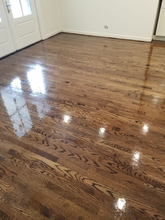 Shiny refinished hardwood floor in an empty room with white walls and doors