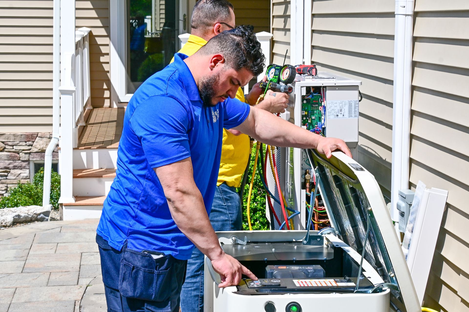 Two men are working on a generator outside of a house.