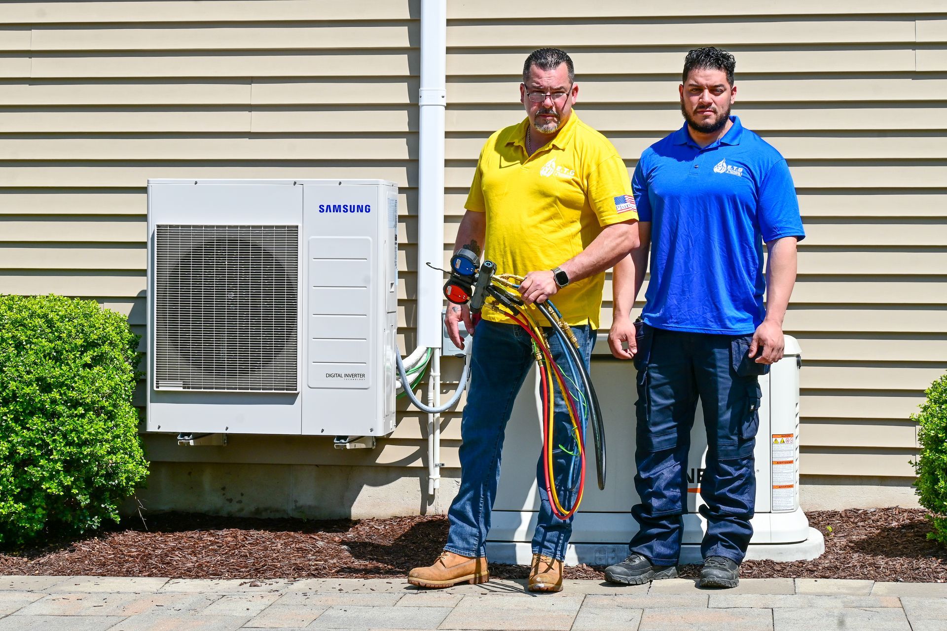 Two men are standing next to each other in front of a house.