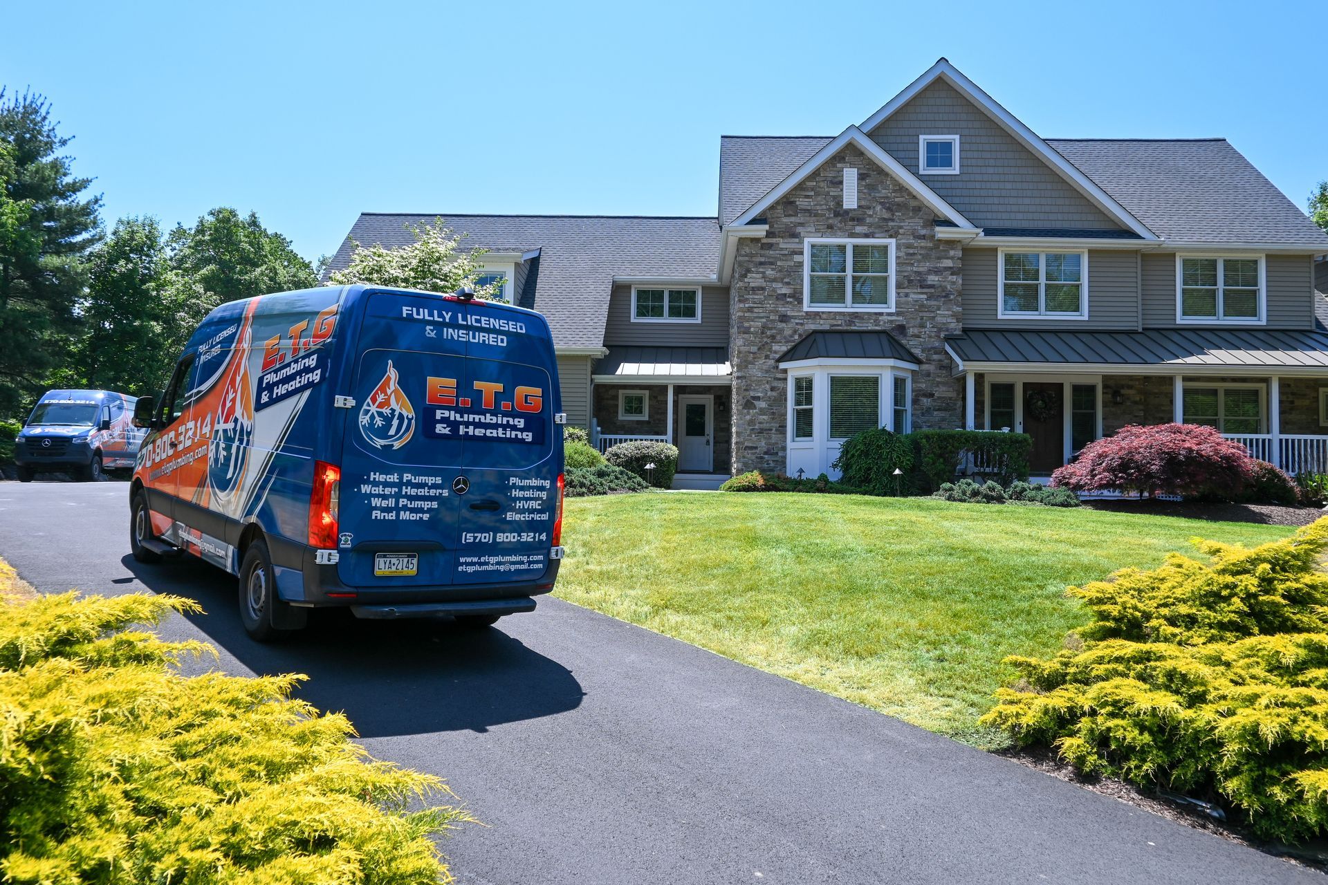 A van is parked in front of a large house.