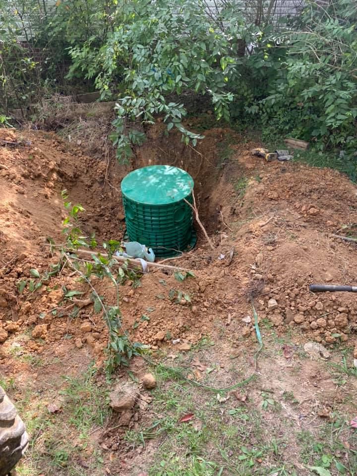 Gray industrial air compressor on wheels in a brick-walled room.