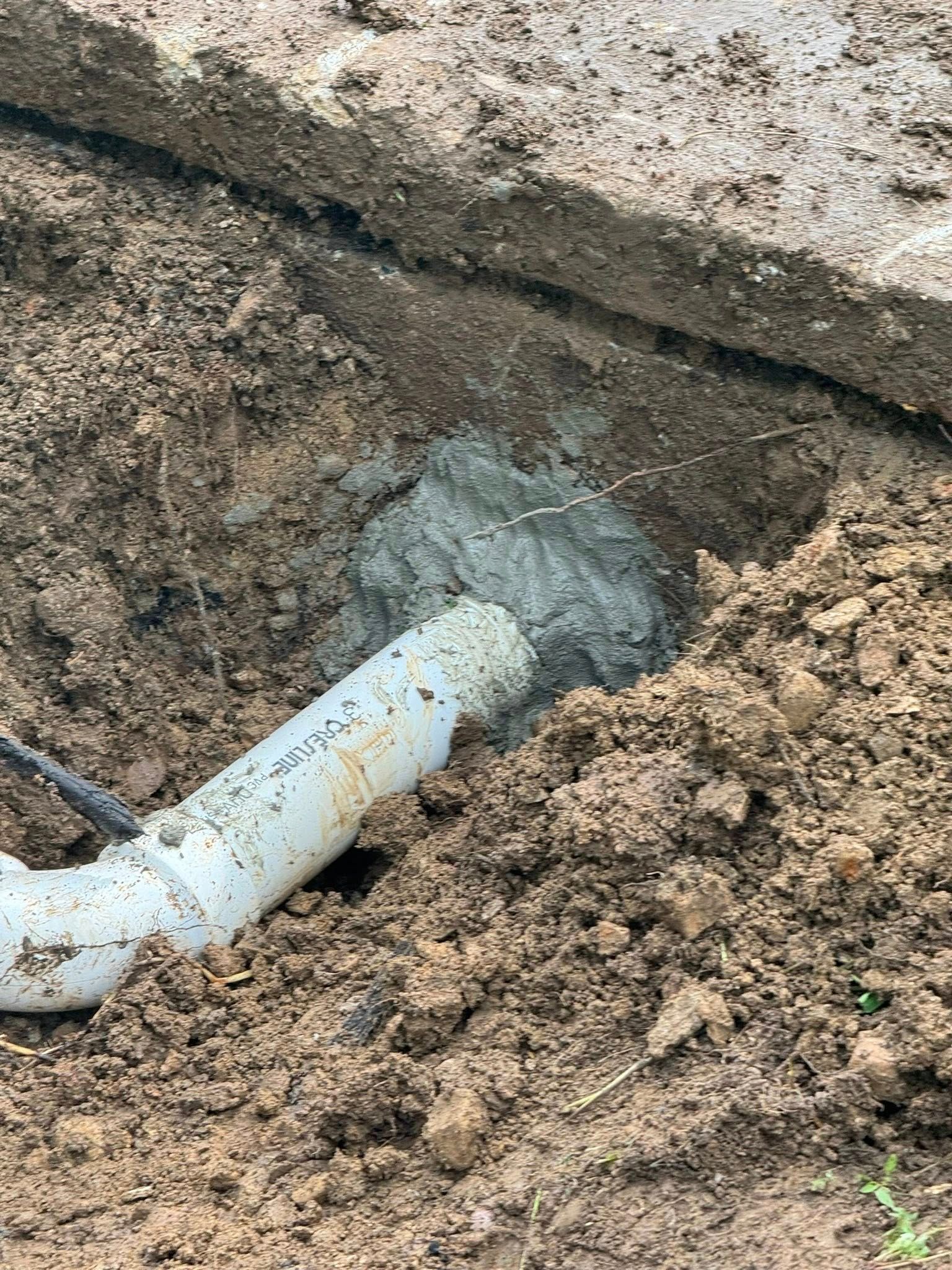 Gray industrial air compressor on wheels in a brick-walled room.
