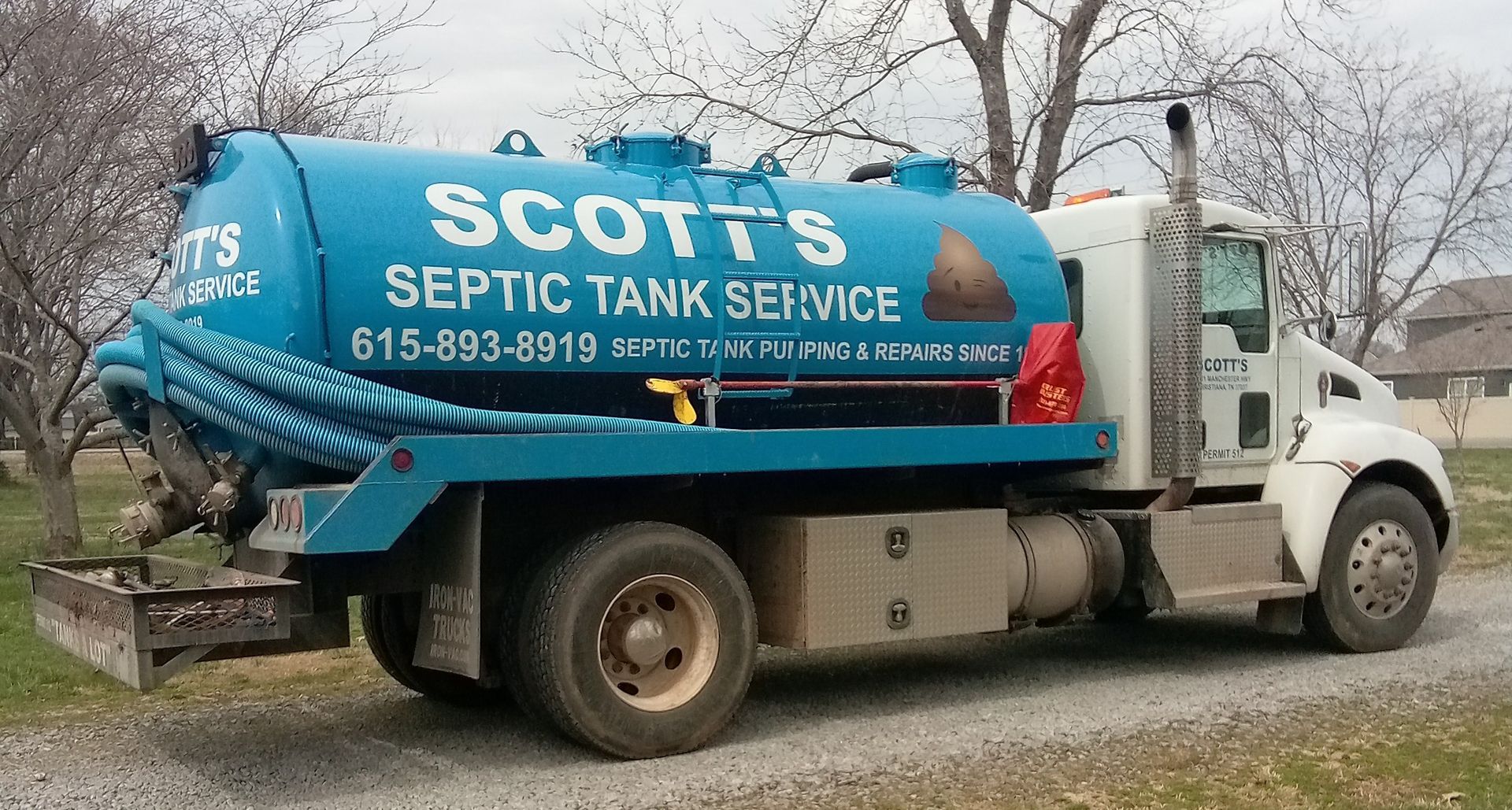 A blue and white septic tank service truck with the name 