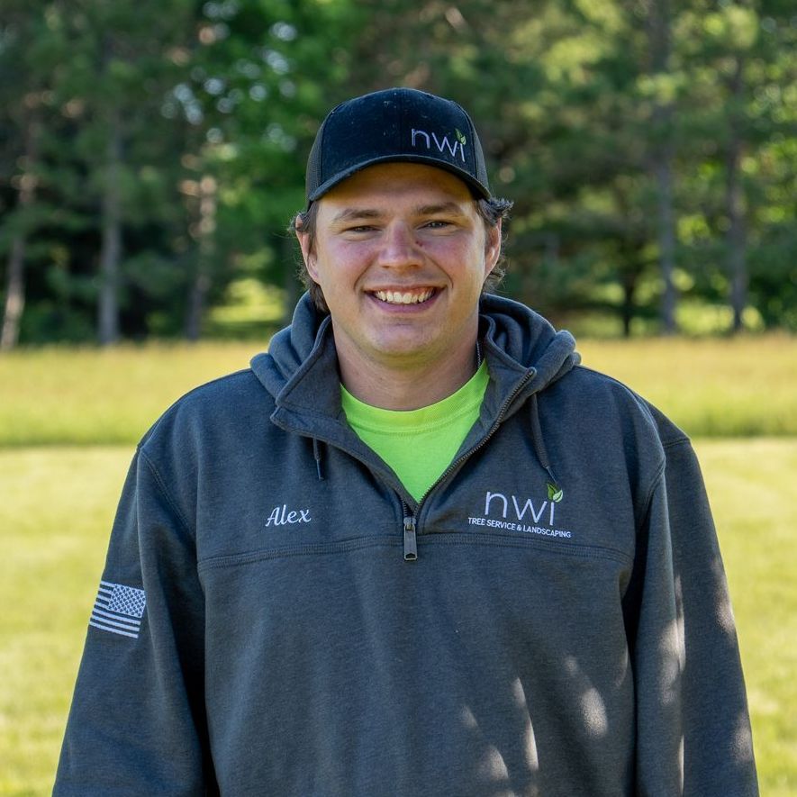 A man wearing a hat and a hoodie is smiling for the camera.