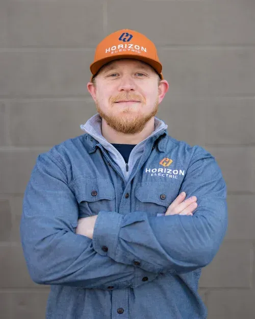 A person wearing a blue shirt and orange cap with 
