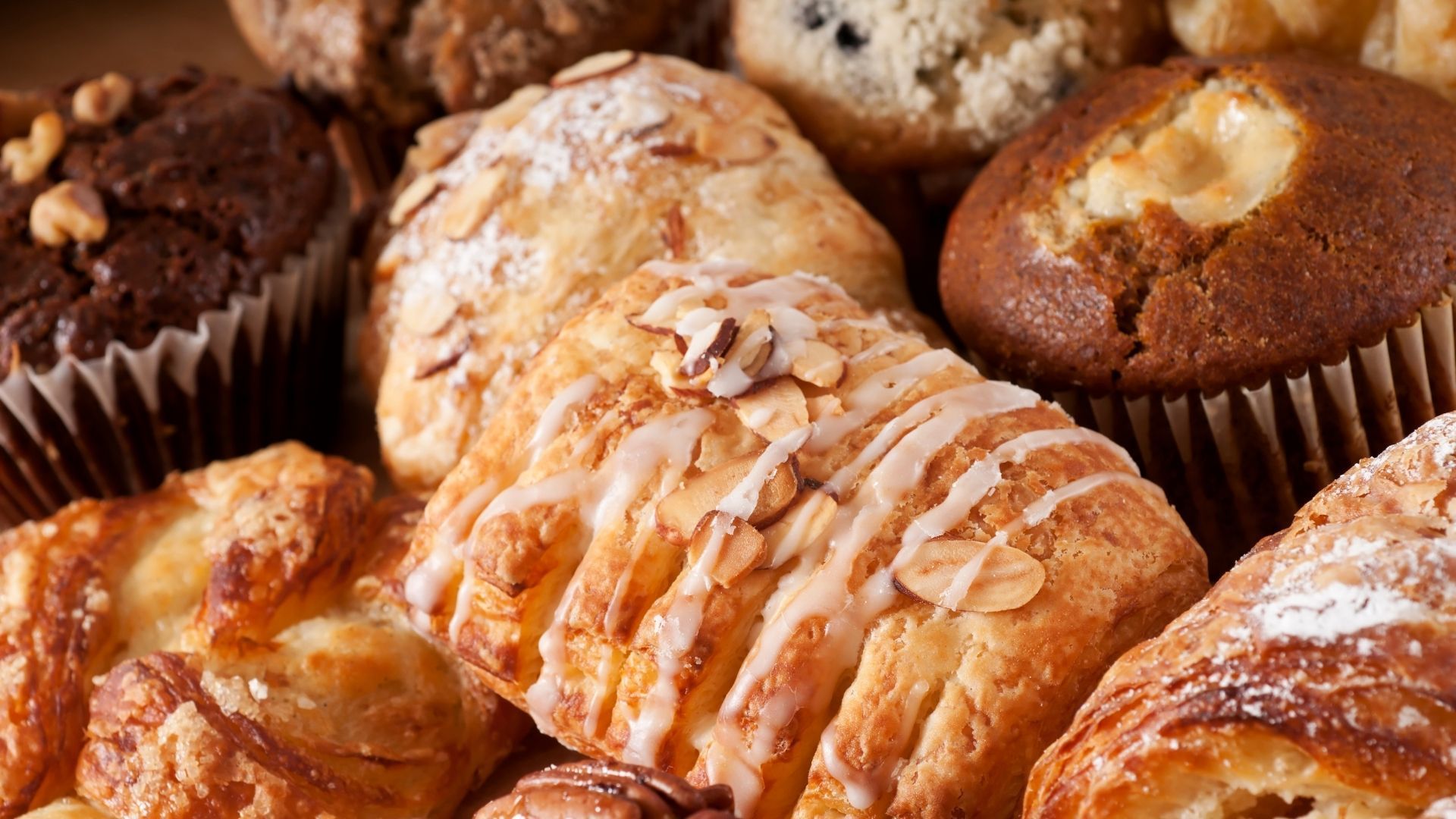 Close-up of various pastries, including muffins and croissants.