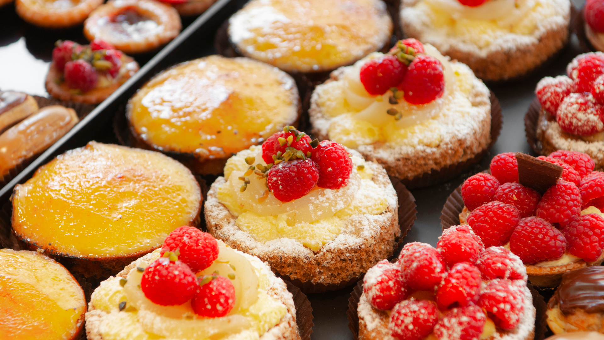 Pastries topped with fruit and powdered sugar.