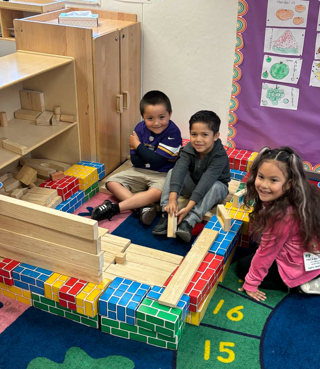 A group of children are playing with blocks in a classroom.