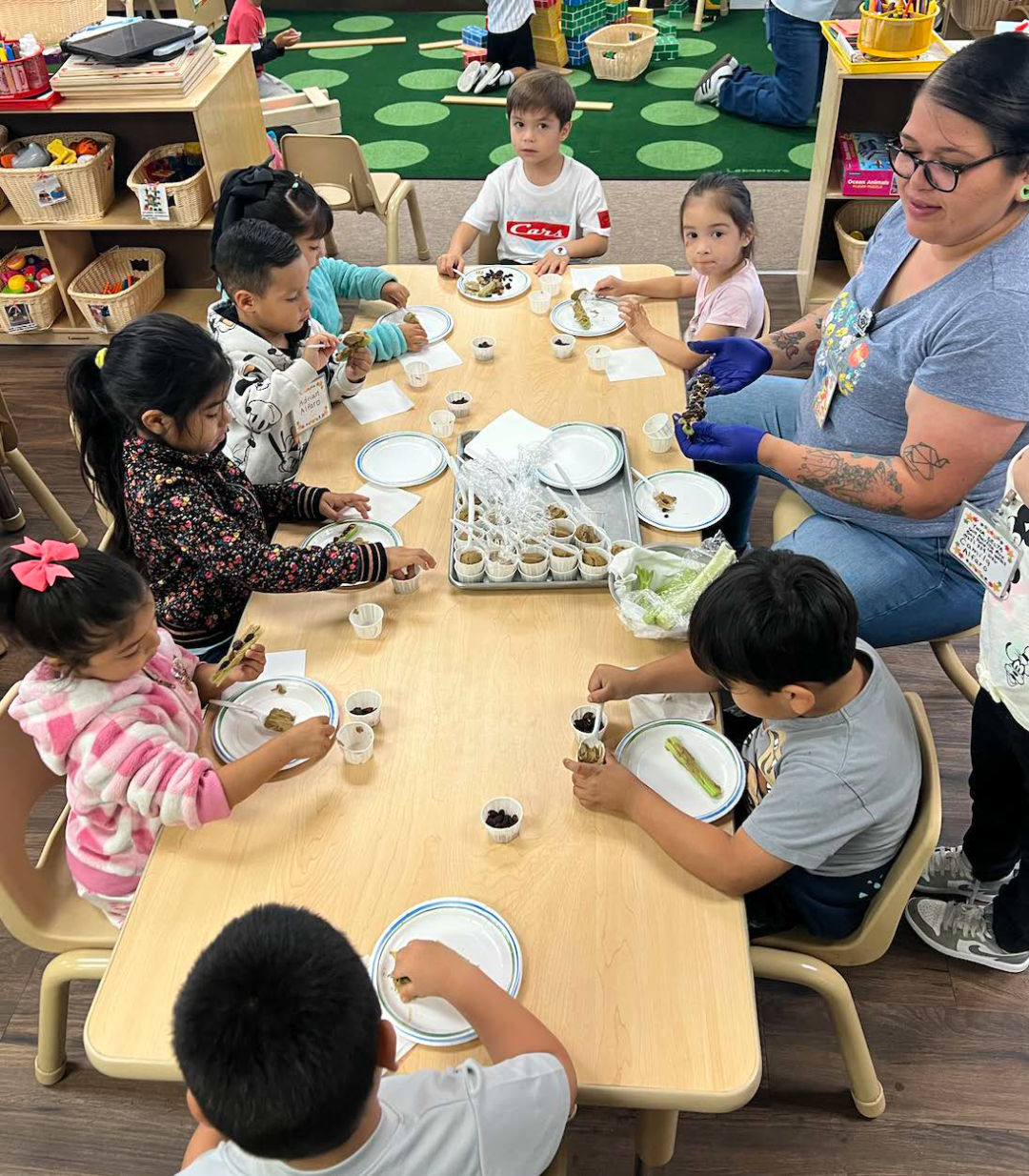 A group of children are sitting at a table eating food.